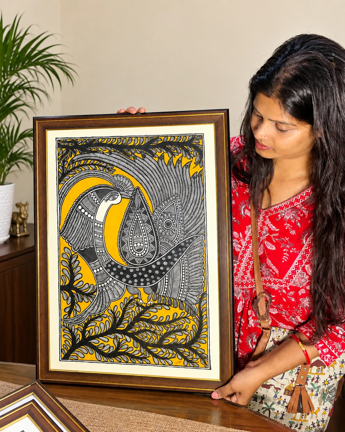 Anu Jha holding a Madhubani painting